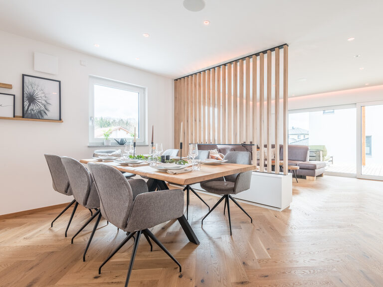 Ein großer Holztisch an dem die Mahlzeiten des Tages aus der Designküche eingenommen werden können.